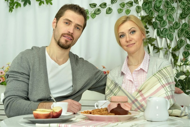 Familia sonriente desayunando en la mesa de la cocina