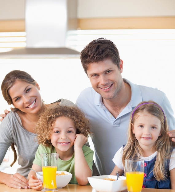 Familia sonriente desayunando