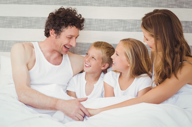 Familia sonriente descansando en la cama