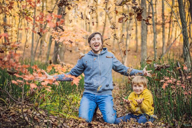 Familia sonriente feliz relajándose en el bosque de otoño