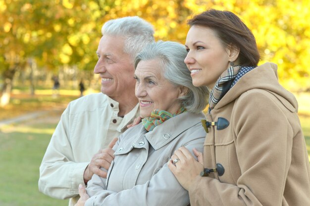 Familia sonriente feliz relajante en el parque otoño