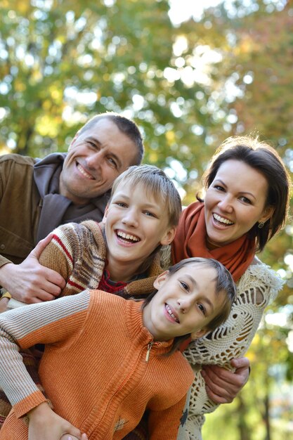 Foto familia sonriente feliz relajante en el parque otoño