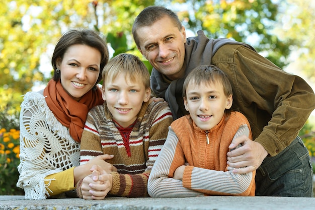 Familia sonriente feliz relajante en el parque otoño