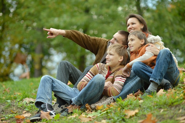 Foto familia sonriente feliz relajante en el parque otoño