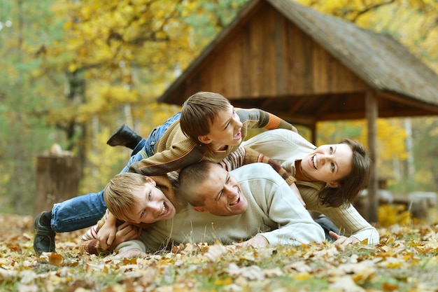 Familia sonriente feliz relajante en el parque otoño