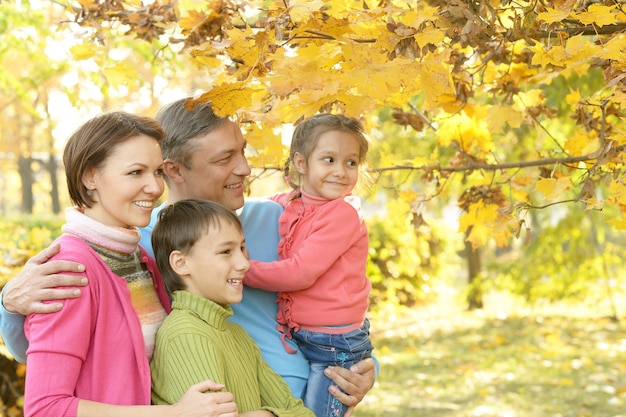 Familia sonriente feliz relajante en el parque otoño