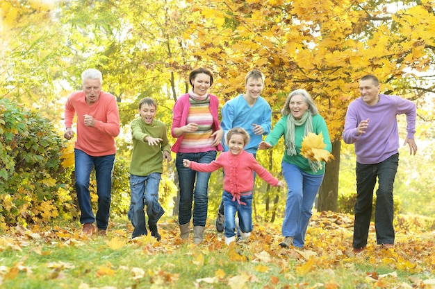Familia sonriente feliz relajante en el parque otoño