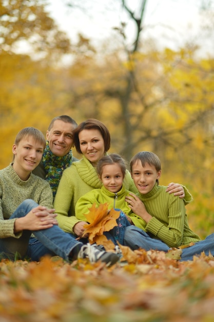 Familia sonriente feliz relajante en el parque otoño