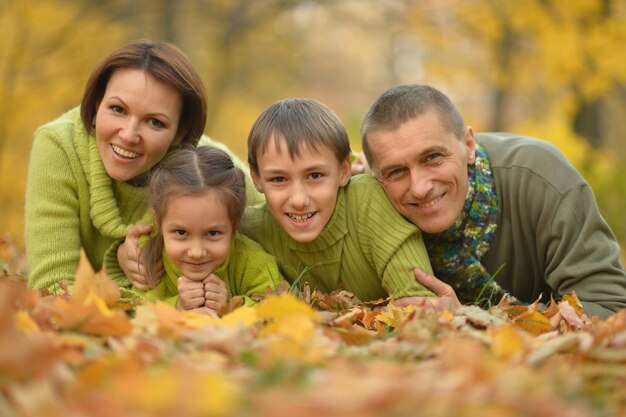 Familia sonriente feliz relajante en el parque otoño