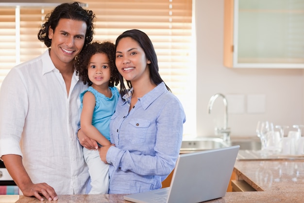 Familia sonriente juntos en la cocina