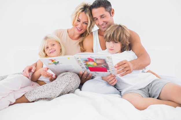 Familia sonriente leyendo una historia juntos