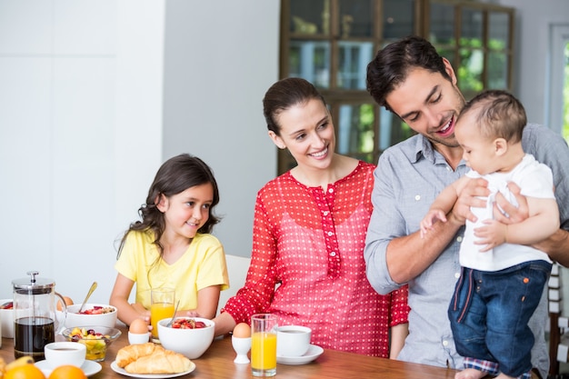 Familia sonriente en la mesa del desayuno