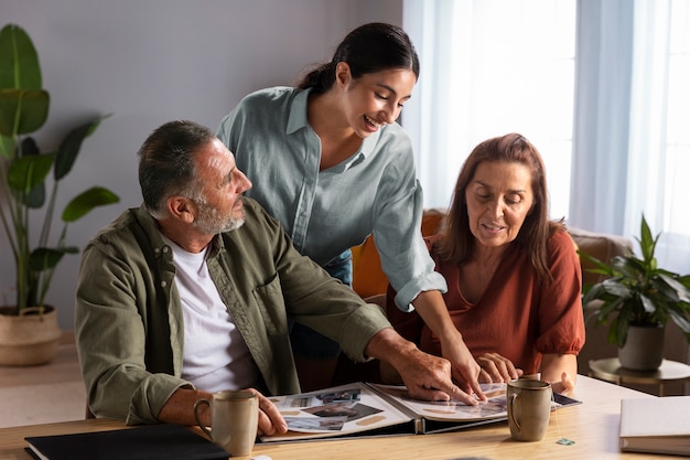 Foto familia sonriente mirando el plano medio del álbum de fotos