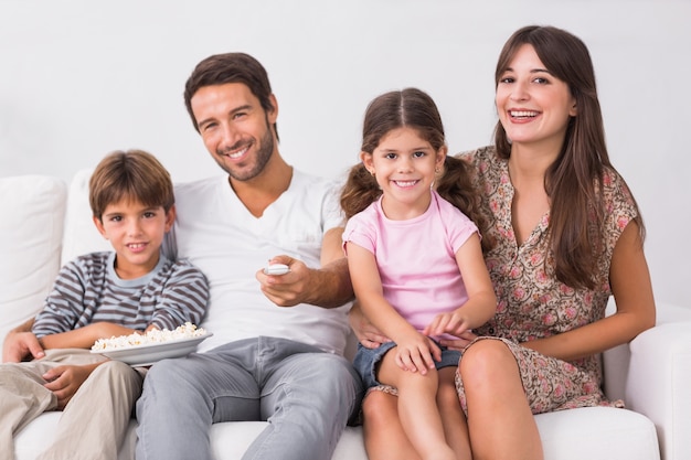 Familia sonriente mirando la televisión