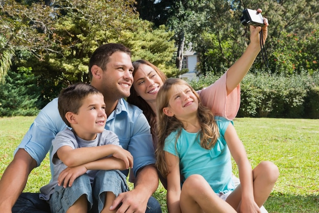 Familia sonriente en un parque tomando fotos