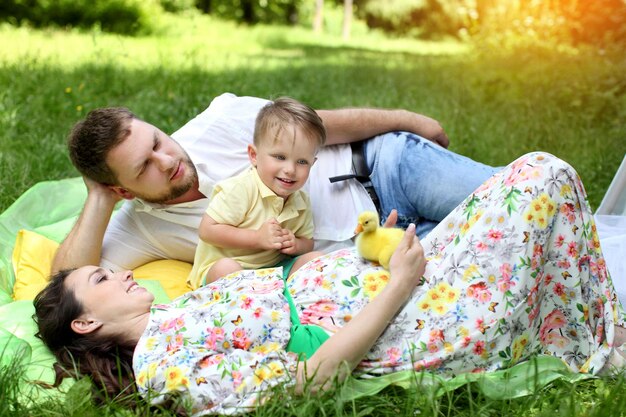 Familia sonriente que va de picnic en el parque