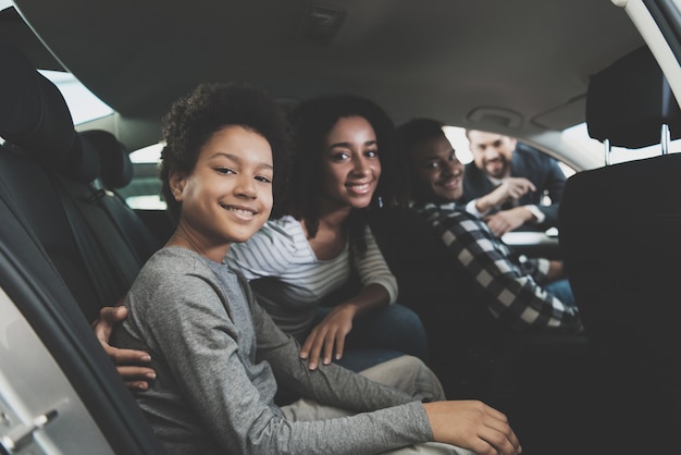 familia sonriente sentada en un auto