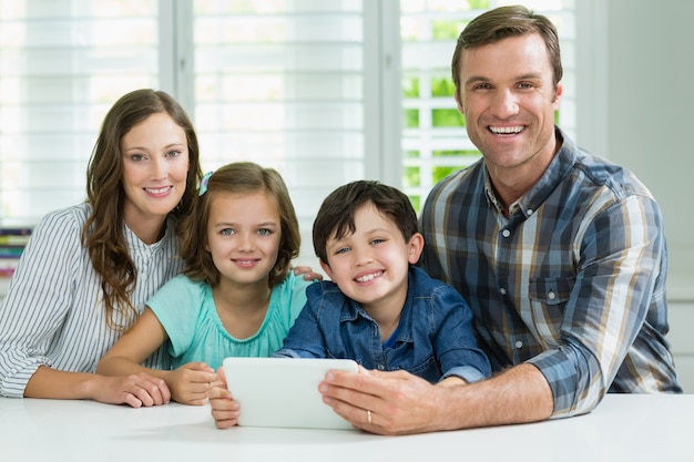 Familia sonriente con tableta digital en la sala de estar en casa