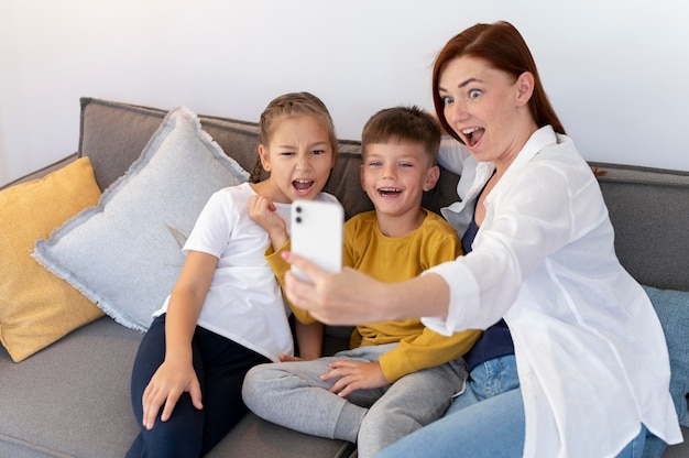 Familia sonriente tomando selfie medio tiro