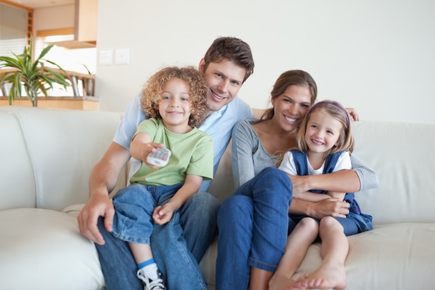 Familia sonriente viendo la televisión juntos