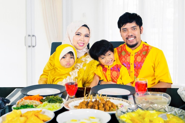Família sorridente comemora eid mubarak na sala de jantar
