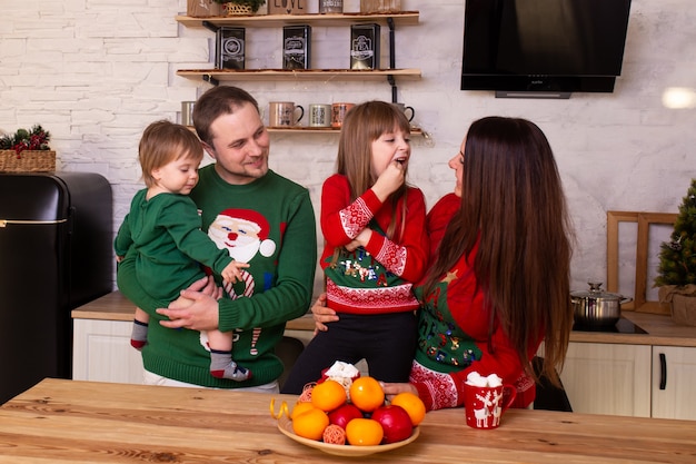 Família sorridente se divertem na cozinha