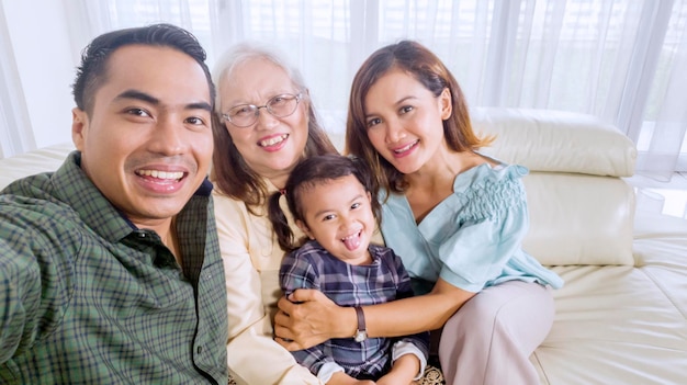 Família sorridente tira uma foto de grupo em casa