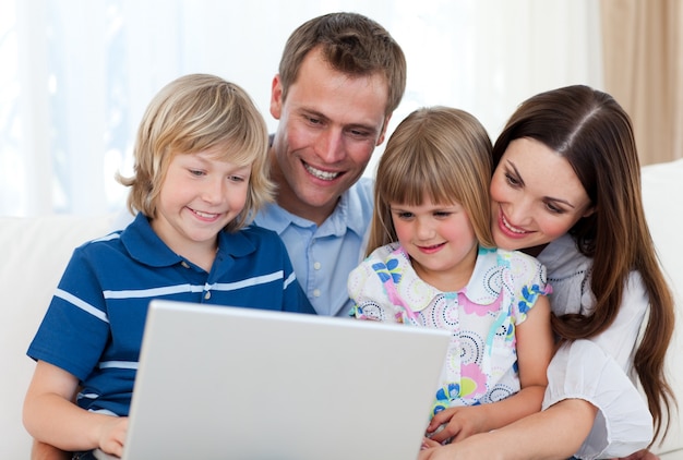 Família sorridente usando um laptop