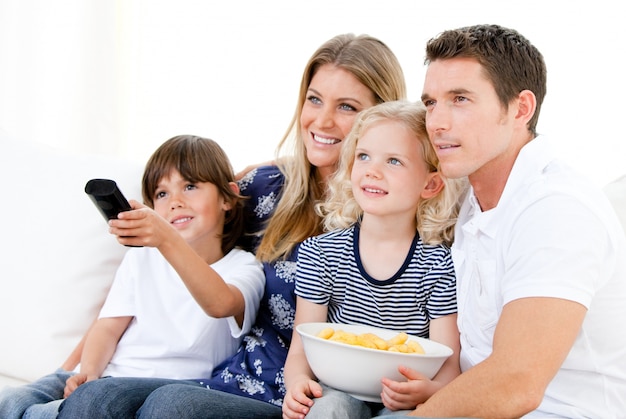Família sorrindo assistindo um filme na televisão