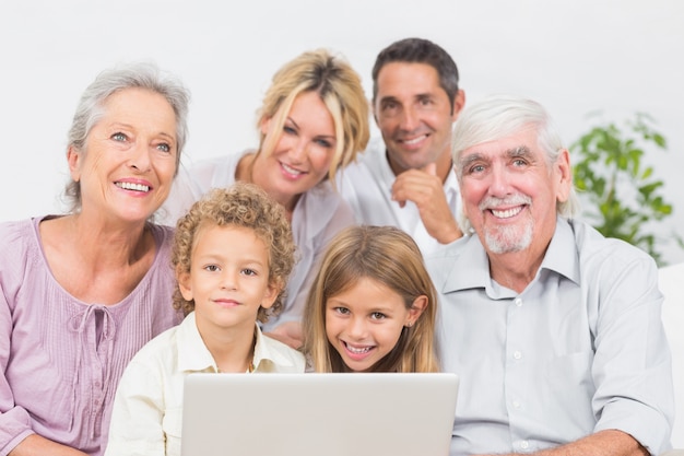 Família sorrindo na frente de uma tela de laptop