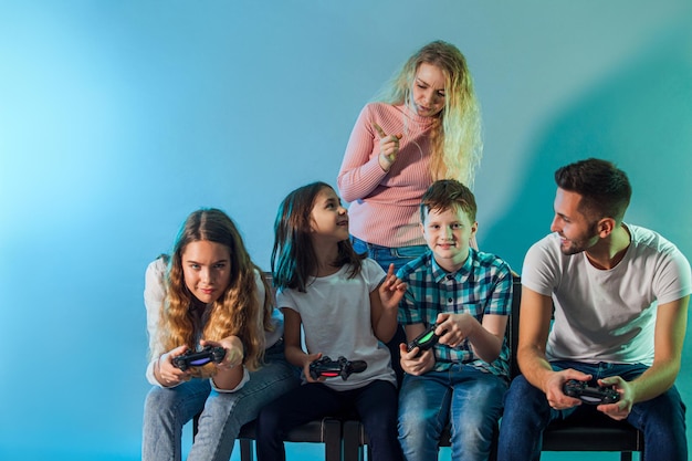 Familia sosteniendo joysticks e iniciando un juego virtual
