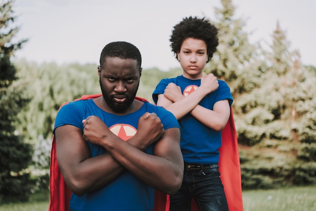 Familia de superhéroes, manos plegadas con rostro serio.