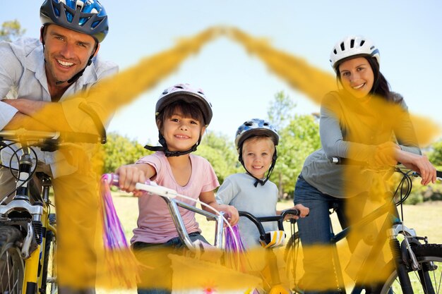 Foto familia con sus bicicletas contra el contorno de la casa en las nubes