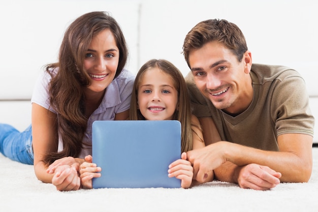 Familia con tableta acostado en una alfombra