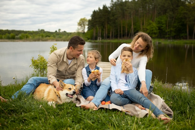 Foto familia de tiro completo con perro al aire libre