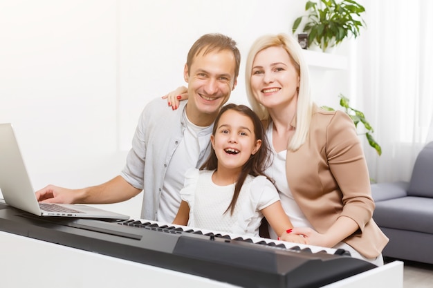 família toca piano digital em casa, aprendizagem online, descanso familiar durante quarentena, auto-isolamento, conceito de educação online. conceito de suporte para entes queridos