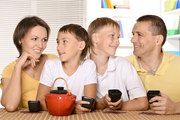 Família tomando chá na mesa da cozinha