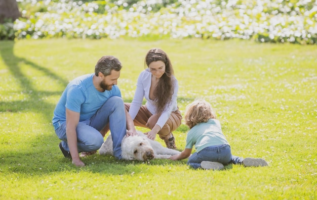 Familia tomando perro para caminar en el campo al aire libre retrato de familia feliz en el parque de verano golpe joven