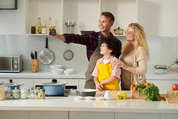 Familia tomando selfie en cocina