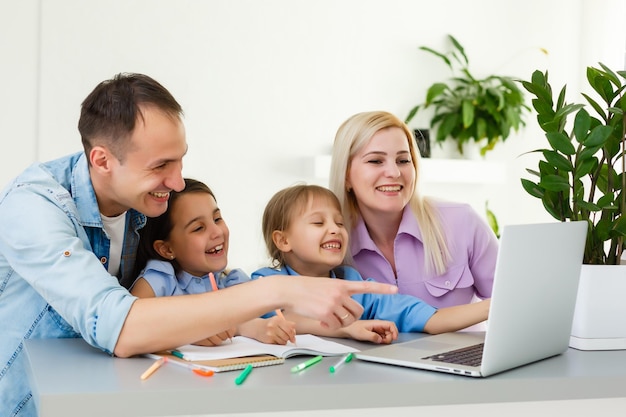 Família trabalhando em um laptop com escritório em casa