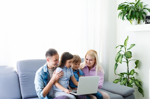 Família trabalhando em um laptop com escritório em casa