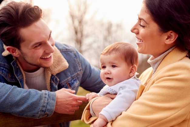 Familia transgénero con bebé disfrutando de un paseo en el campo de otoño o invierno