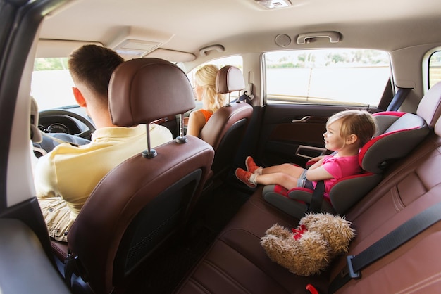 família, transporte, segurança, viagem e conceito de pessoas - pais felizes com criança dirigindo no carro