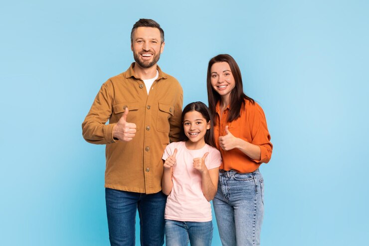 Familia de tres gestos de pulgares hacia arriba sonriendo sobre un fondo azul