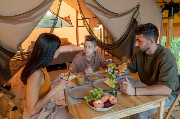 Familia de tres interactuando por mesa servida durante el desayuno