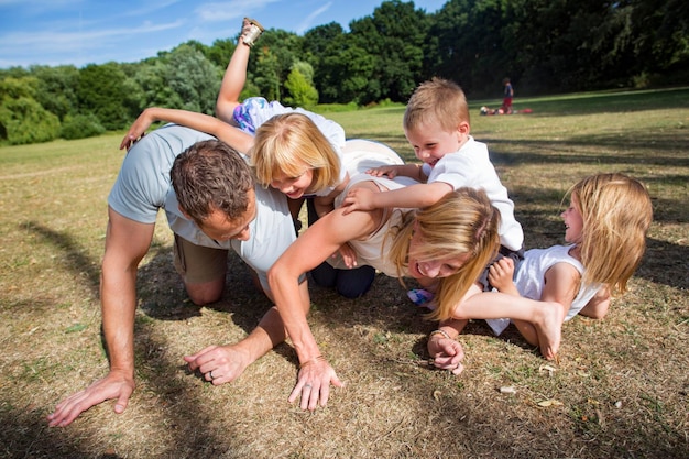 Familia con tres niños jugando en un parque.