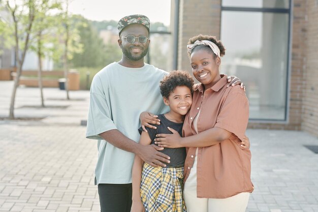 Familia de tres de pie en la ciudad.