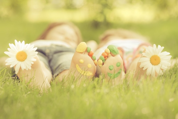 Familia tumbada en la hierba verde Niños divirtiéndose al aire libre en el parque de primavera Imagen en tonos retro