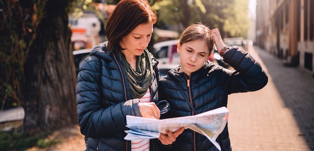 Familia de turistas perdidos usando el mapa de la ciudad