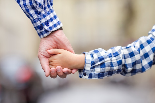 Familia unida de la mano en la calle en la ciudad europea